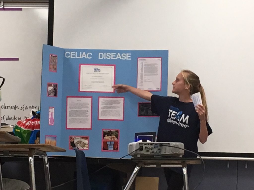 Vivienne Cannon holds a poster board illustrating information about celiac disease.